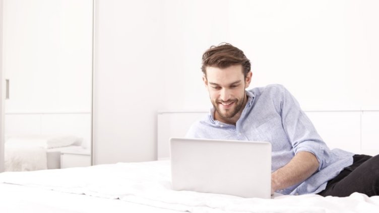 Man working on Laptop in hotel room during pandemic