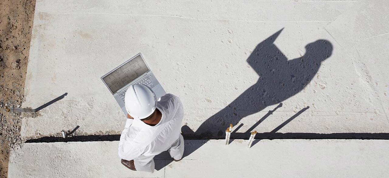 Top view of an architect working on his laptop at the construction site