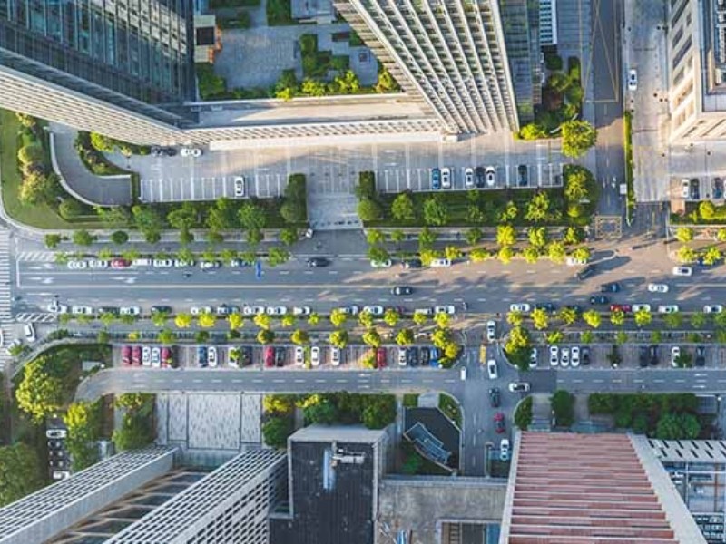 Vue aérienne d'une ville avec des grands bâtiments et des routes au premier plan