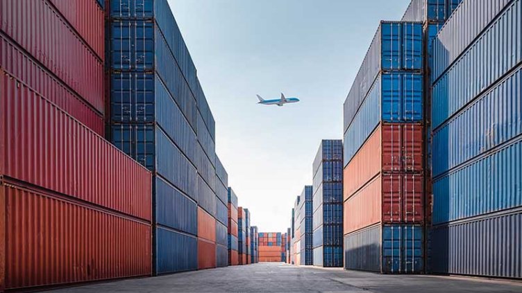 A plane above a port with containers