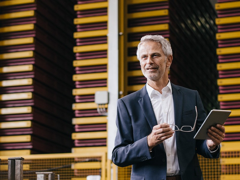 Un homme avec une tablette à la main présente les transformations de la Supply Chain