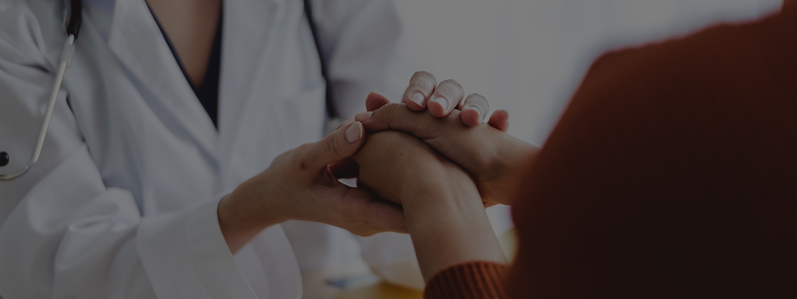 Woman Doctor woman holding the hand of woman patient