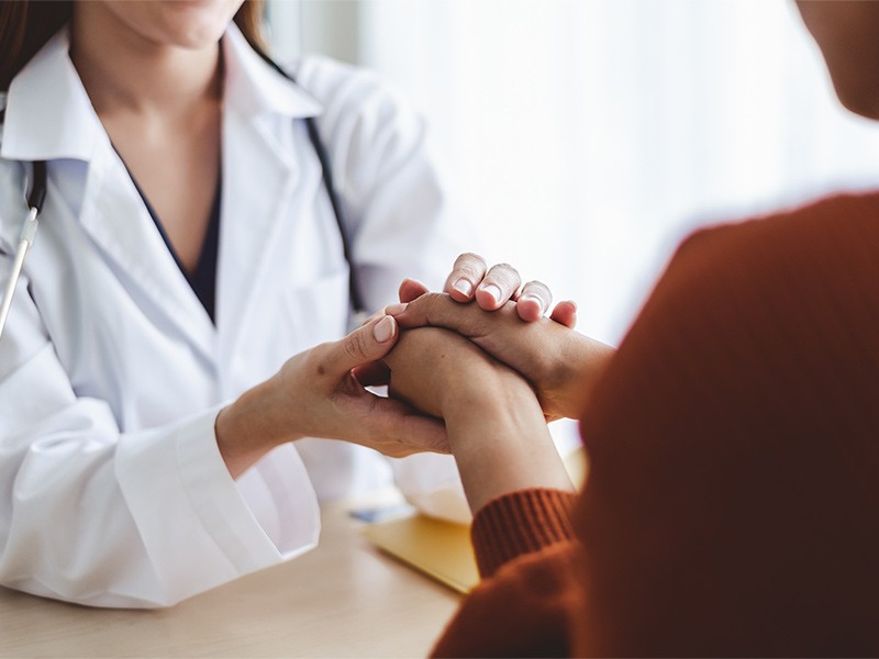 Woman Doctor woman holding the hand of woman patient