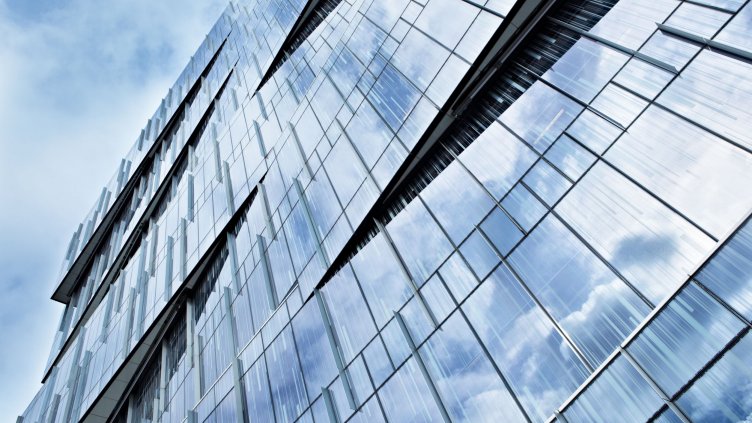 17092568 - corporate building full of glass windows reflecting the sky at afternoon