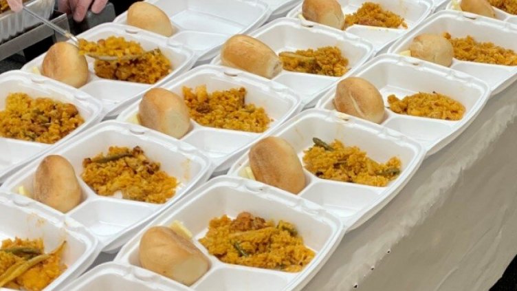 Serving of food in the plates for the homeless people