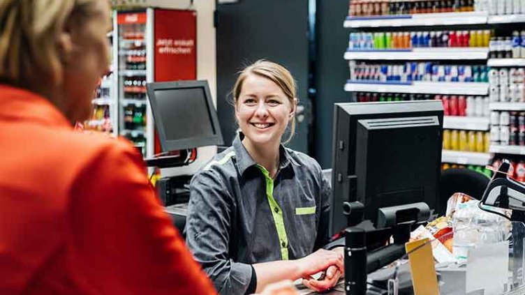 Cashier and customer communicating while buying groceries at a supermarket store