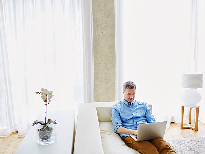 A man working while sitting on Sofa