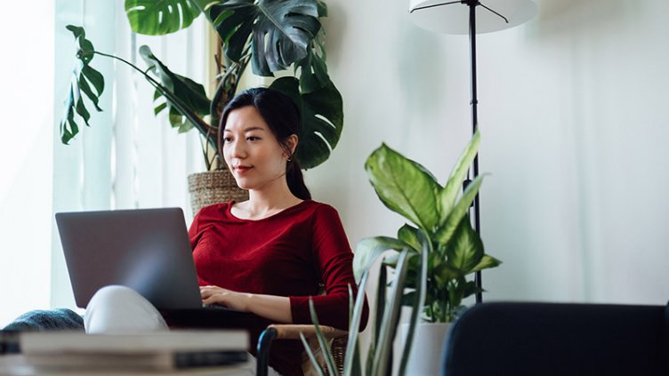 An asian Women sitting and working on a laptop	