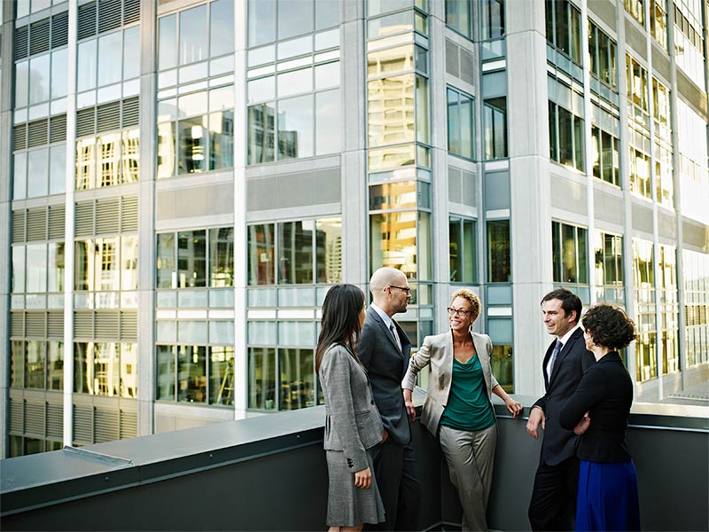 Diverse group of business people in discussion on a terrace in a central business district location