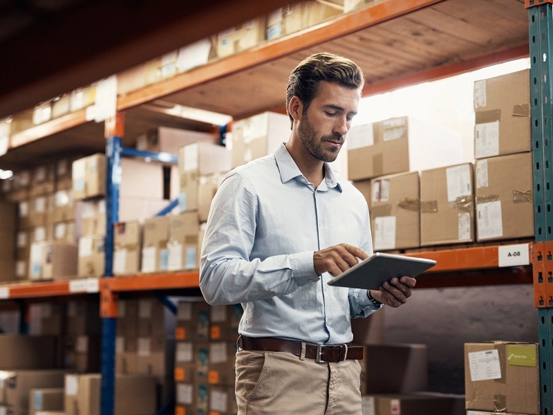 Shot of a young man using a digital tablet while working in a warehouse