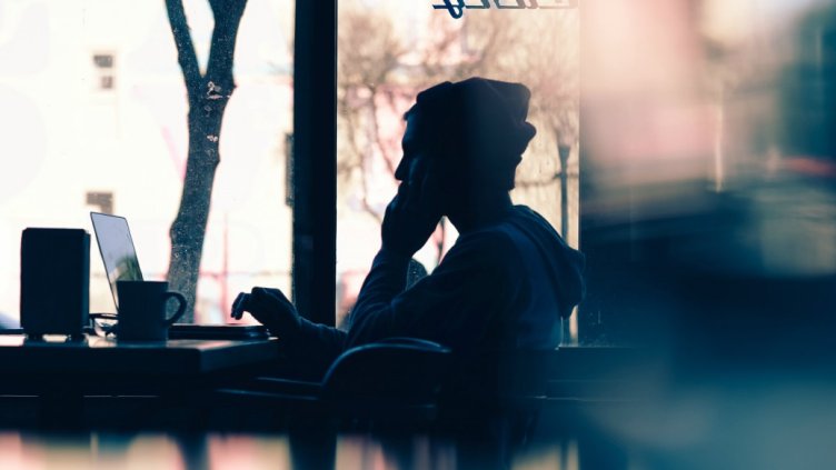 silhouette of man working in café