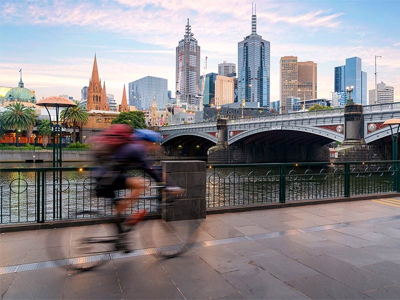 A male riding bicycle in speed over the bridge